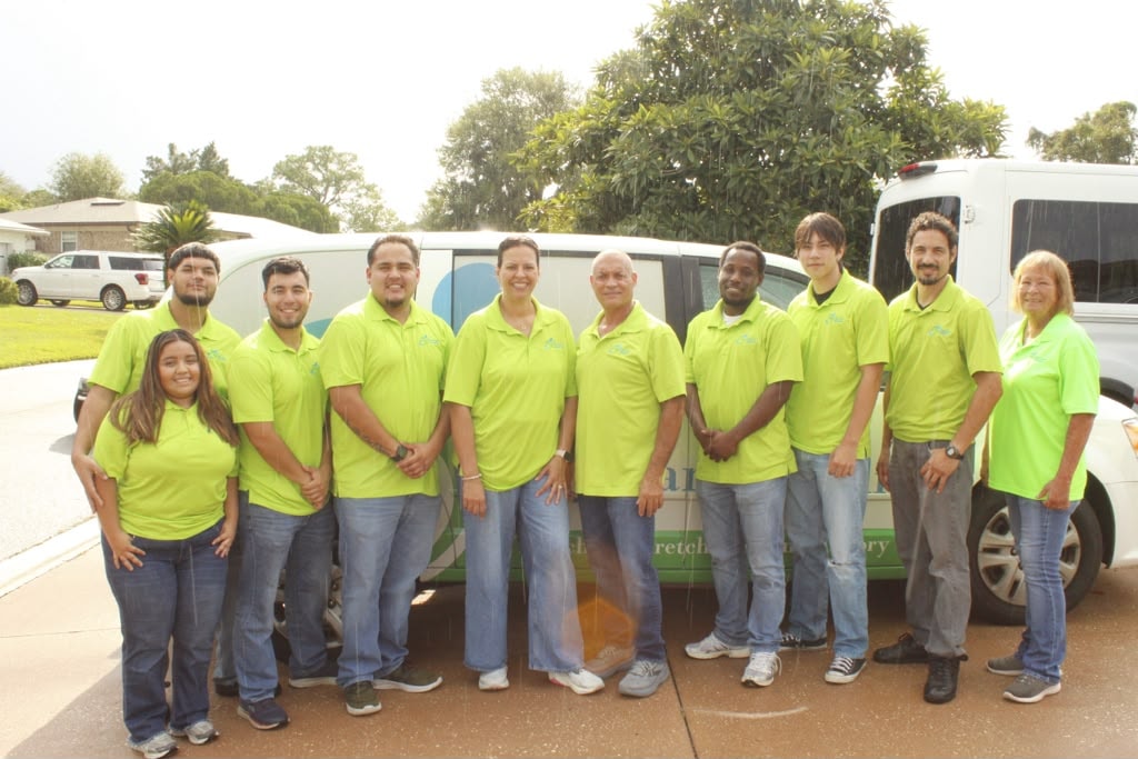 Clay Care Mobility team members beside service vehicles