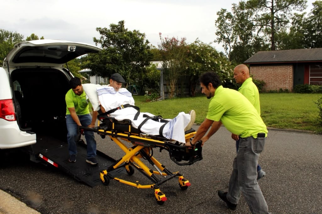 Patient transport team assisting a passenger on a stretcher